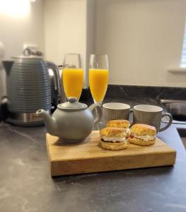 two sandwiches on a cutting board with two glasses of orange juice at 1 Merchants Gate - 2 bedroom, city apartment with private parking in York