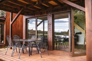 a patio with a table and chairs on a deck at Urocza Przystań Siecino in Siecino