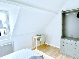 Schlafzimmer mit einem Bett und einem Schreibtisch in der Unterkunft L'agapanthe in Saint-Gildas-de-Rhuys