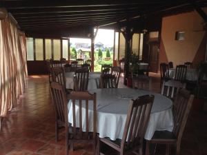ein Esszimmer mit Tisch, Stühlen und Fenstern in der Unterkunft Hotel Adial in Adjud
