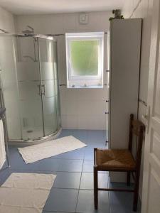baño con ducha, silla y ventana en Authentique maison en pierre de 160 m2 au calme, en Reignac