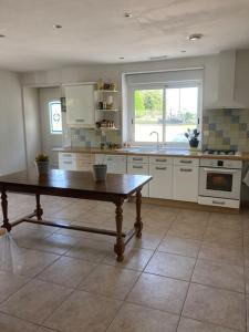 Una gran cocina con una mesa en el medio. en Authentique maison en pierre de 160 m2 au calme, en Reignac