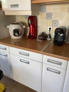 a kitchen counter with a red appliance on it at Authentique maison en pierre de 160 m2 au calme in Reignac