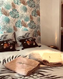 uma cama com almofadas e toalhas com uma parede em chez LULU appartement neuf au coeur de cozzano em Cozzano