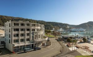 a large white building next to a street with a harbor at Picton Waterfront Apartments in Picton