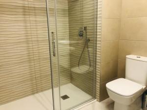 uma casa de banho com um chuveiro e um WC. em Residencial Alegria 12 em Torrevieja