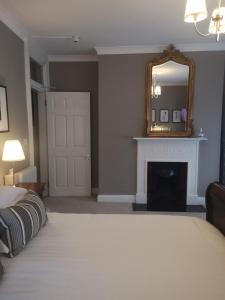 a bedroom with a bed and a mirror and a fireplace at Shaw Suite in Dublin