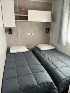 Łóżko lub łóżka w pokoju w obiekcie MH 3 chambres, camping Les Dunes de Contis, Landes
