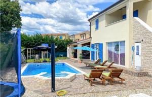 - une piscine avec des chaises et une table à côté d'une maison dans l'établissement 5 Bedroom Awesome Home In Naselje Muzini, à Tomišići
