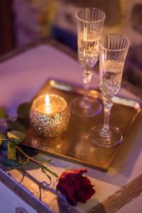 a tray with two glasses and a candle on it at San Lazzo Luxury Room - ROOM & PERSONAL SPA in Castiglion Fiorentino