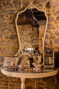 a table with a mirror on a brick wall at San Lazzo Luxury Room - ROOM & PERSONAL SPA in Castiglion Fiorentino