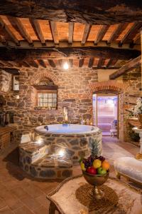 een grote badkamer met een bad in een stenen muur bij San Lazzo Luxury Room - ROOM & PERSONAL SPA in Castiglion Fiorentino