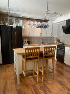 een keuken met een houten aanrecht en 2 stoelen bij Lovely house with a beautiful view in Jokkmokk in Jokkmokk