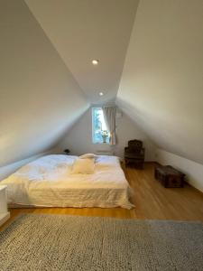 sypialnia z dużym łóżkiem na poddaszu w obiekcie Lilla Villan w mieście Höganäs