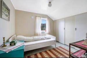 un dormitorio con una cama y una ventana en Charming holiday home, en Tromsø