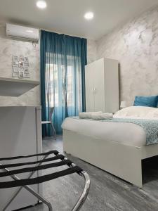 Schlafzimmer mit einem großen weißen Bett und blauen Vorhängen in der Unterkunft CLALE ROOMS in Neapel