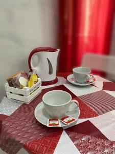 einen Tisch mit zwei Tassen und einer Teekanne drauf. in der Unterkunft CLALE ROOMS in Neapel