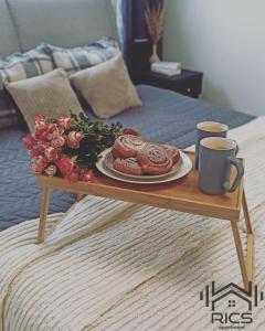 a table with a plate of food on a bed at Rics Apartment in Valga