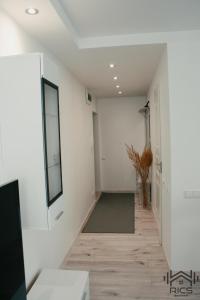 a hallway with white walls and a green rug at Rics Apartment in Valga