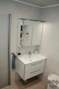 a bathroom with a white sink and a mirror at Rics Apartment in Valga