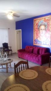 a living room with a purple couch and a painting at Monte Mar 7A in Divisadero