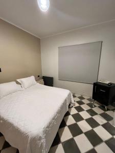 1 dormitorio con cama blanca y suelo a cuadros en Gomez Point Mendoza en Mendoza