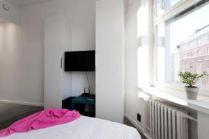 a white bedroom with a bed and a window at Stylish studio in the centre in Helsinki