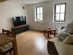 a living room with a couch and a flat screen tv at Ferienwohnung sentio-comfortable Saalfeld in Saalfeld