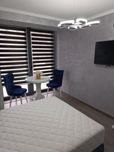 - une chambre avec un lit, une table et des chaises dans l'établissement Apartment 1 Novi Sad, à Novi Sad