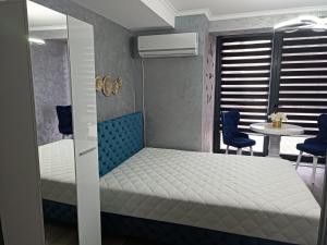 a bedroom with a bed and two chairs and a table at Apartment Dunav in Novi Sad