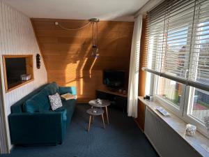 a living room with a green couch and a table at Apartment Haus Julia in Norderney