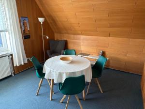 a dining room with a table and green chairs at Apartment Haus Julia in Norderney