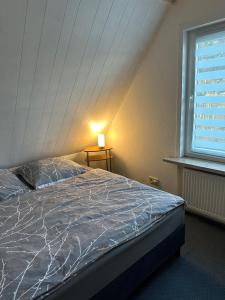Bett in einem Zimmer mit einem großen Fenster in der Unterkunft Apartment Haus Julia in Norderney