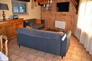 - un salon avec un canapé et une table dans l'établissement Gîte le Manège Normand, à Grand Camp