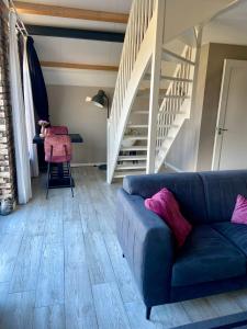 - un salon avec un canapé et un escalier dans l'établissement Slapen an de Veenvaart, à Nieuw-Amsterdam