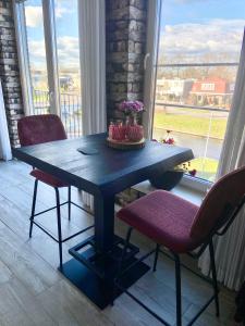 une table avec deux chaises et une table avec des fleurs. dans l'établissement Slapen an de Veenvaart, à Nieuw-Amsterdam