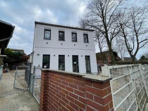 a white house with windows on top of a brick wall at Neubauwohnung im Herzen Panketal in Panketal