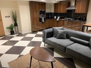 uma sala de estar com um sofá e um piso em xadrez em Apartment in Old Trafford em Manchester
