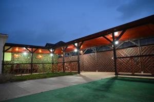 un patio al aire libre con toldo por la noche en Pensiunea Savas, en Costinesti
