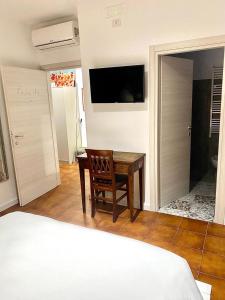 a bedroom with a bed and a table and a television at Da li Poteri in Colfiorito