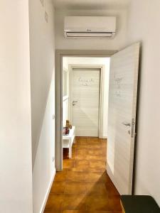 a hallway with a white door and a bathroom at Da li Poteri in Colfiorito