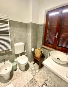 a bathroom with a white toilet and a sink at Da li Poteri in Colfiorito