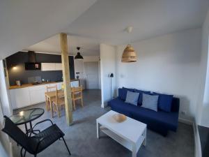 a living room with a blue couch and a table at Słoneczny Zakątek Sominy in Sominy
