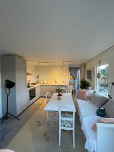 ein Wohnzimmer mit einem weißen Sofa und einem Tisch in der Unterkunft Lilla Villan in Höganäs