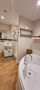 a bathroom with a sink and a bath tub at GOLD Penthouse Room 5min to Basingstoke Hospital in Basingstoke