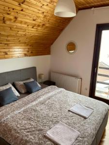 a bedroom with a large bed with blue pillows at Kuća sa pogledom na Tornik in Zlatibor