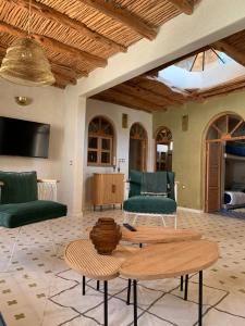 - un salon avec des chaises vertes et une table dans l'établissement Dar Gecko, à Sidi Kaouki