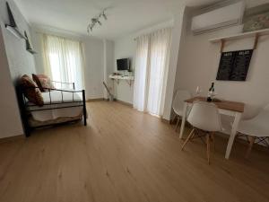 sala de estar con cama, mesa y sillas en APN Hatabin, en Granada