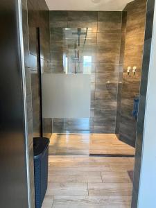 La salle de bains est pourvue d'une douche avec une porte en verre. dans l'établissement Slapen an de Veenvaart, à Nieuw-Amsterdam