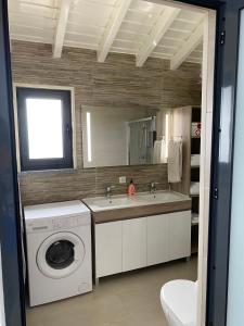uma casa de banho com uma máquina de lavar roupa e um lavatório em Casa Bela Vista em Ponta Delgada